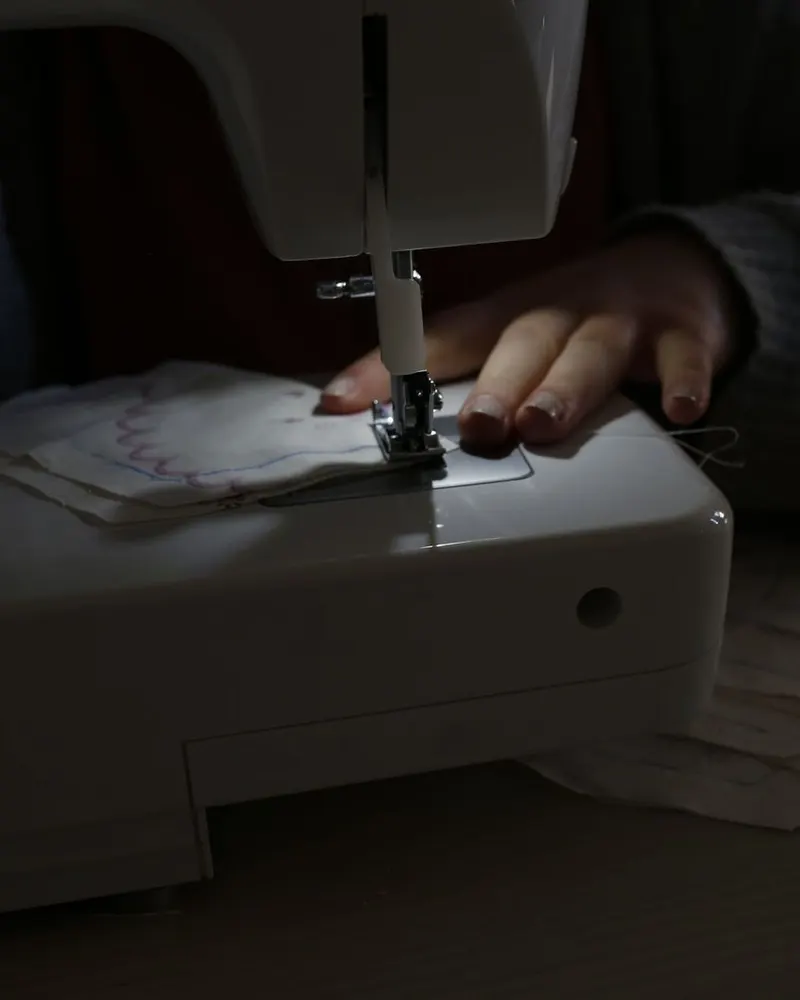 Ruke vode tkaninu kroz šivaću mašinu